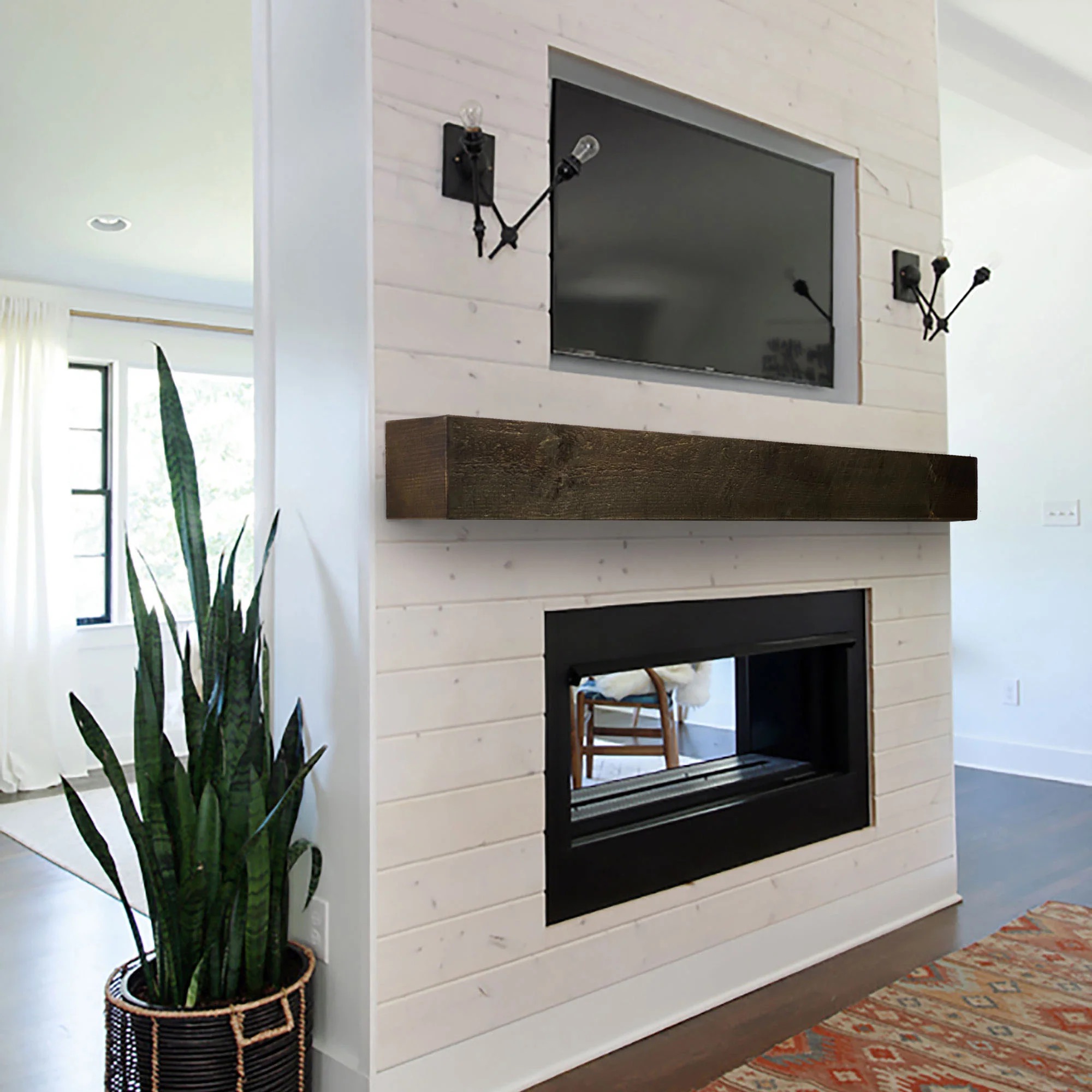 Modern rustic floating walnut mantel below a wall-mounted TV